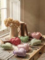 Heart-shaped decorative items on a wooden table with a window in the background