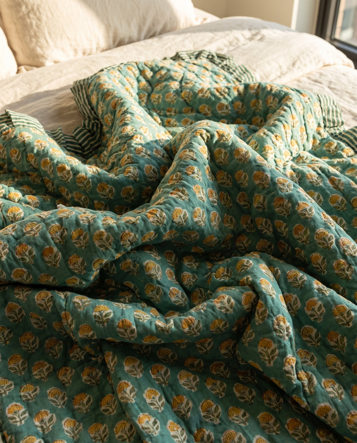 Elephant Meadow reversible cotton baby blanket, side two, bed editorial