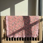 Petal Play reversible cotton baby blanket, side one, crib rail
