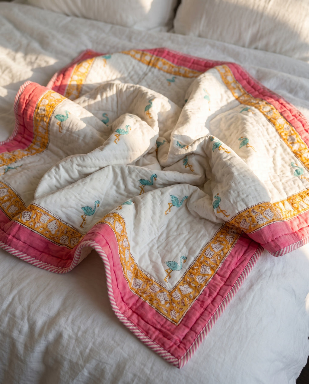 Flamingo Daydreams reversible cotton baby blanket, side one, bed editorial