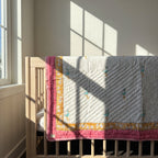 Flamingo Daydreams reversible cotton baby blanket, side one, crib rail
