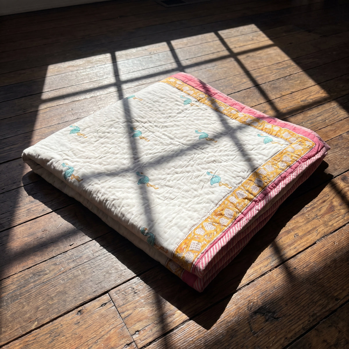 Flamingo Daydreams reversible cotton baby blanket, side one, floor