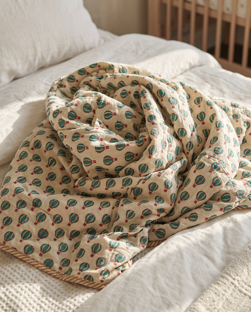Balloon Adventures reversible cotton baby blanket, side two, bed editorial
