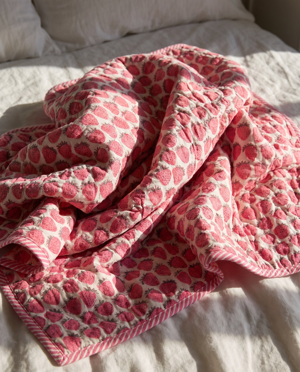 Berry Picnic reversible cotton baby blanket, side one, bed editorial