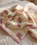 Unicorn Wishes reversible cotton baby blanket, side one, bed editorial