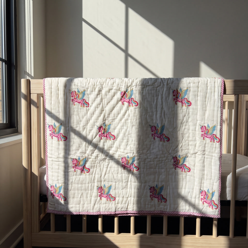Unicorn Wishes reversible cotton baby blanket, side one, crib rail