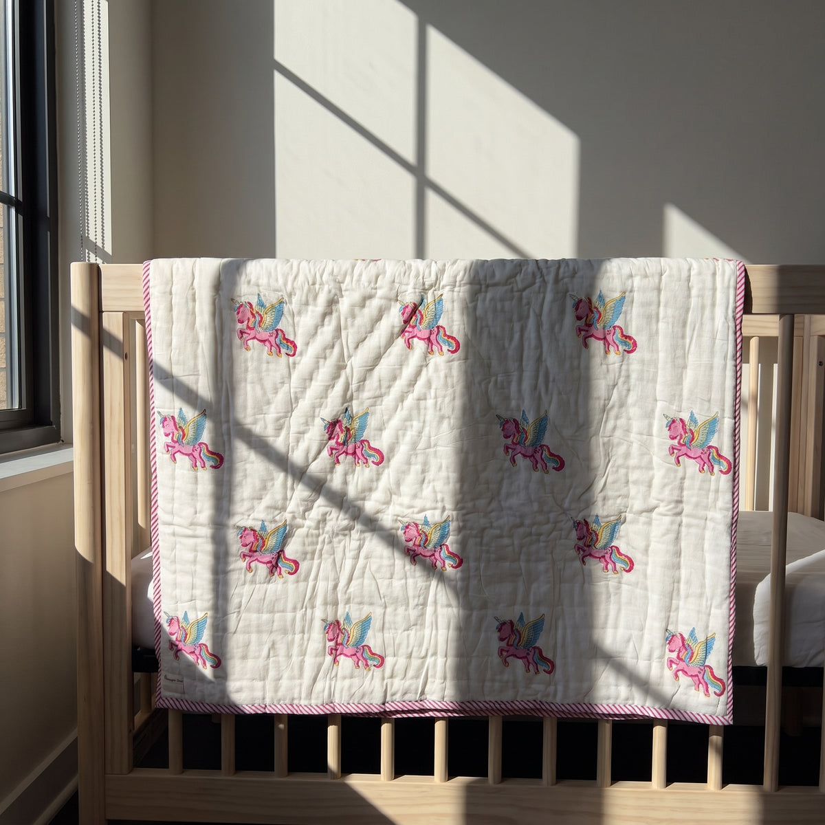 Unicorn Wishes reversible cotton baby blanket, side one, crib rail