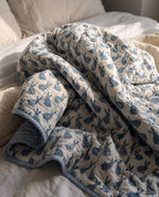 Bunny Trails reversible cotton baby blanket, side one, bed editorial