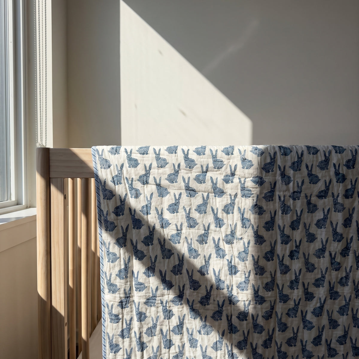 Bunny Trails reversible cotton baby blanket, side one, crib rail