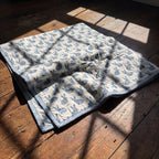 Bunny Trails reversible cotton baby blanket, side one, floor