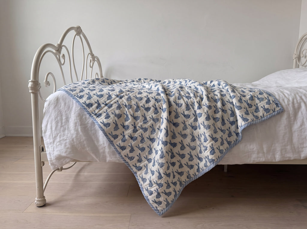 Bunny Trails reversible cotton baby blanket, side one, iron bed