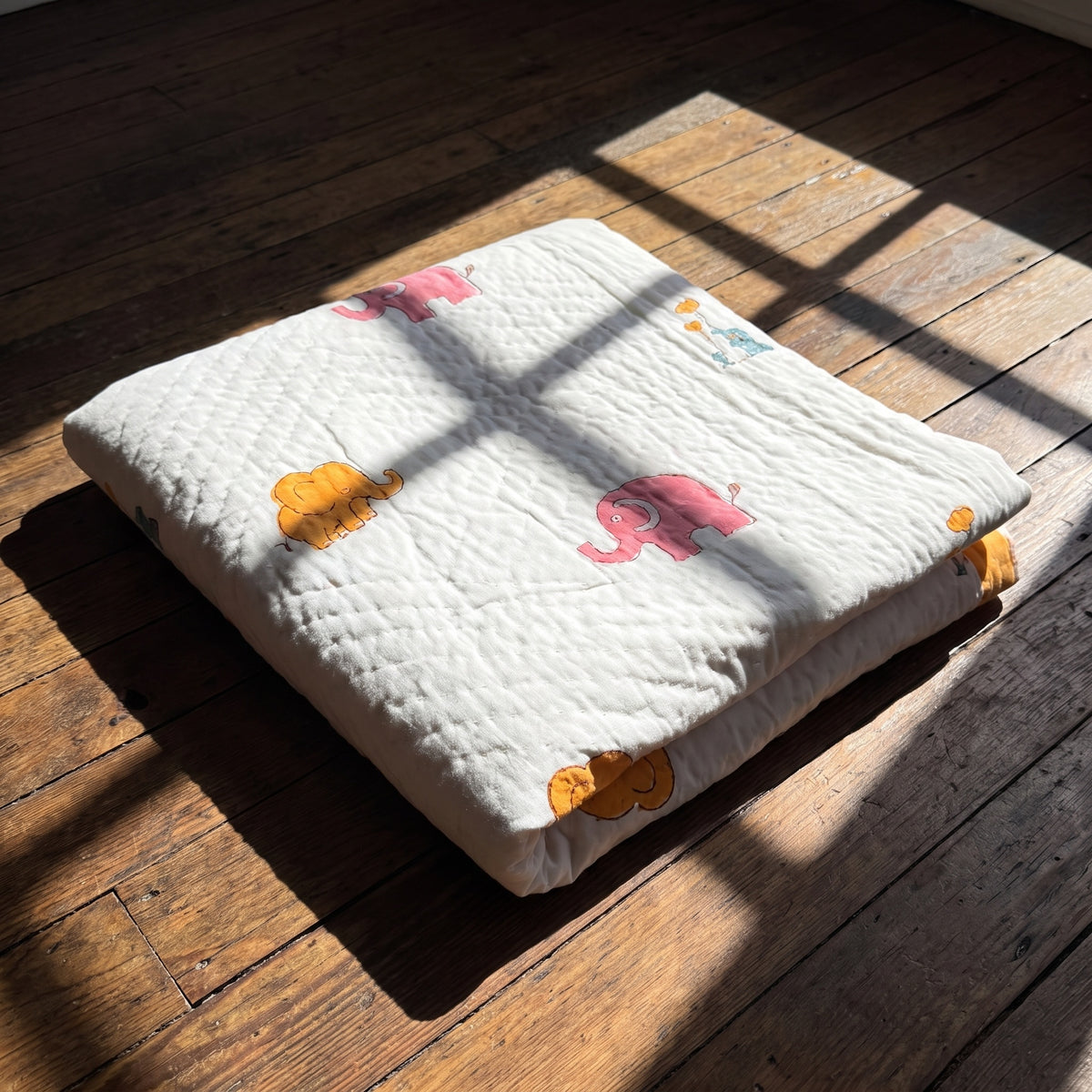 Elephant Wishes reversible cotton baby blanket, side one, floor
