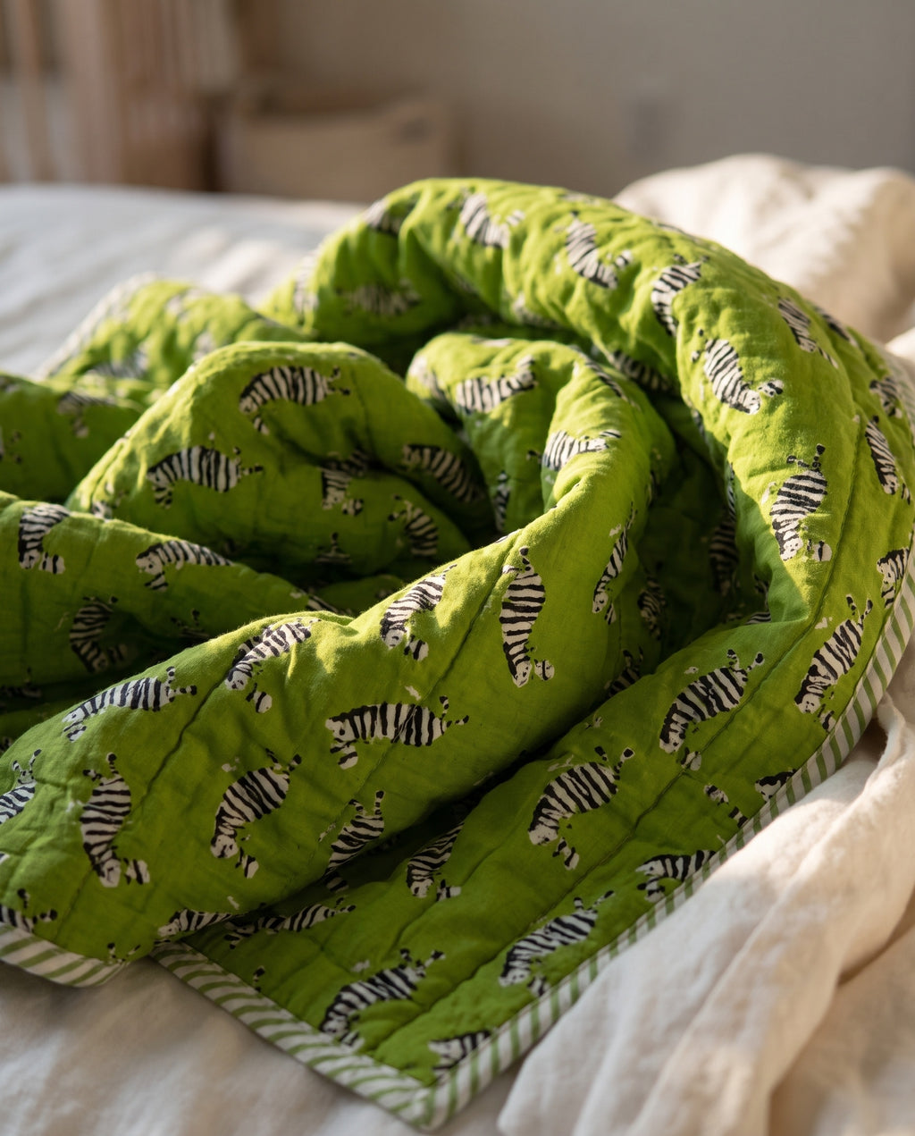 Zebra Wanderings reversible cotton baby blanket, side one, bed editorial