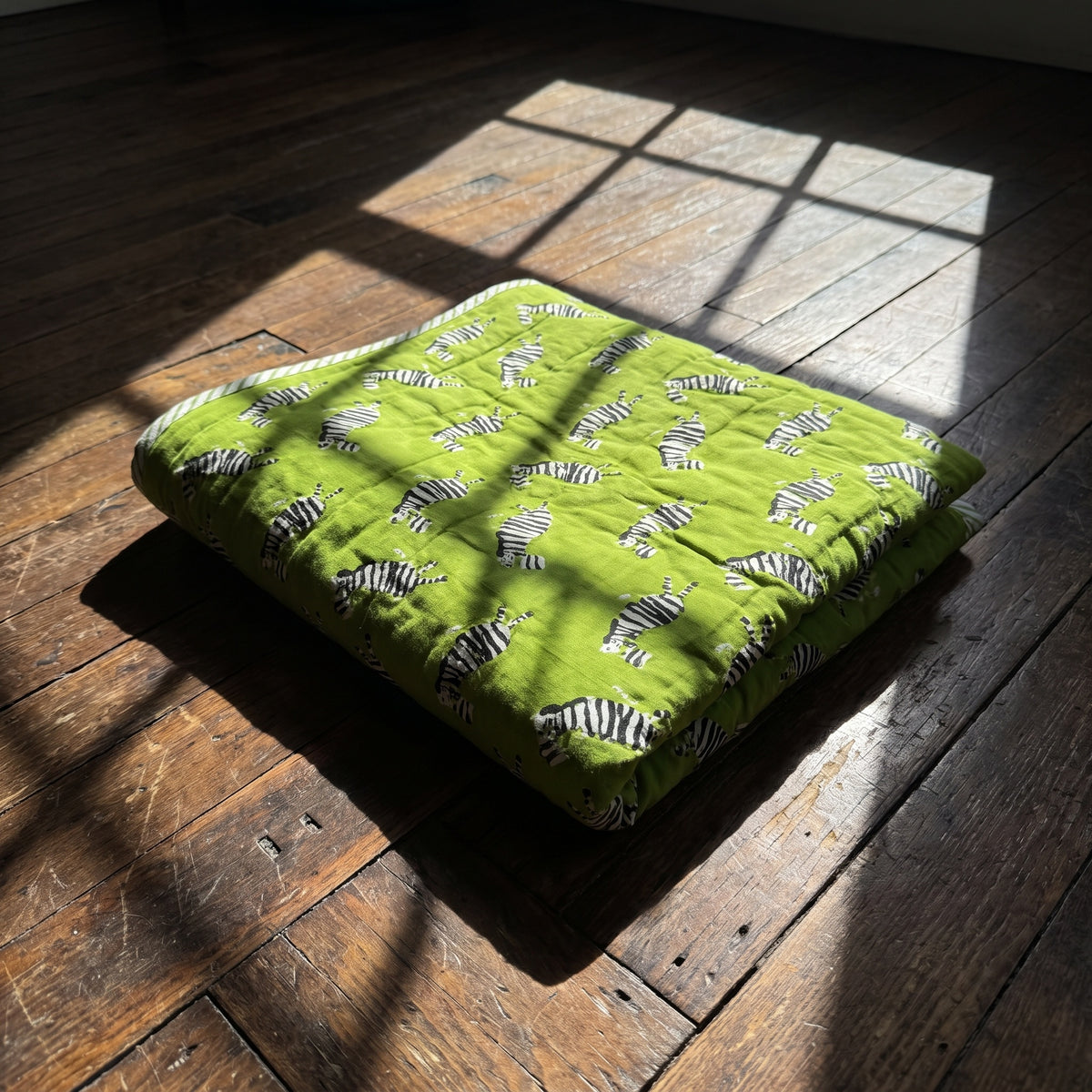 Zebra Wanderings reversible cotton baby blanket, side one, floor