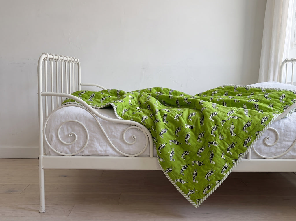Zebra Wanderings reversible cotton baby blanket, side one, iron bed