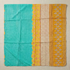 Textile with turquoise, yellow, and beige patterns on a beige background