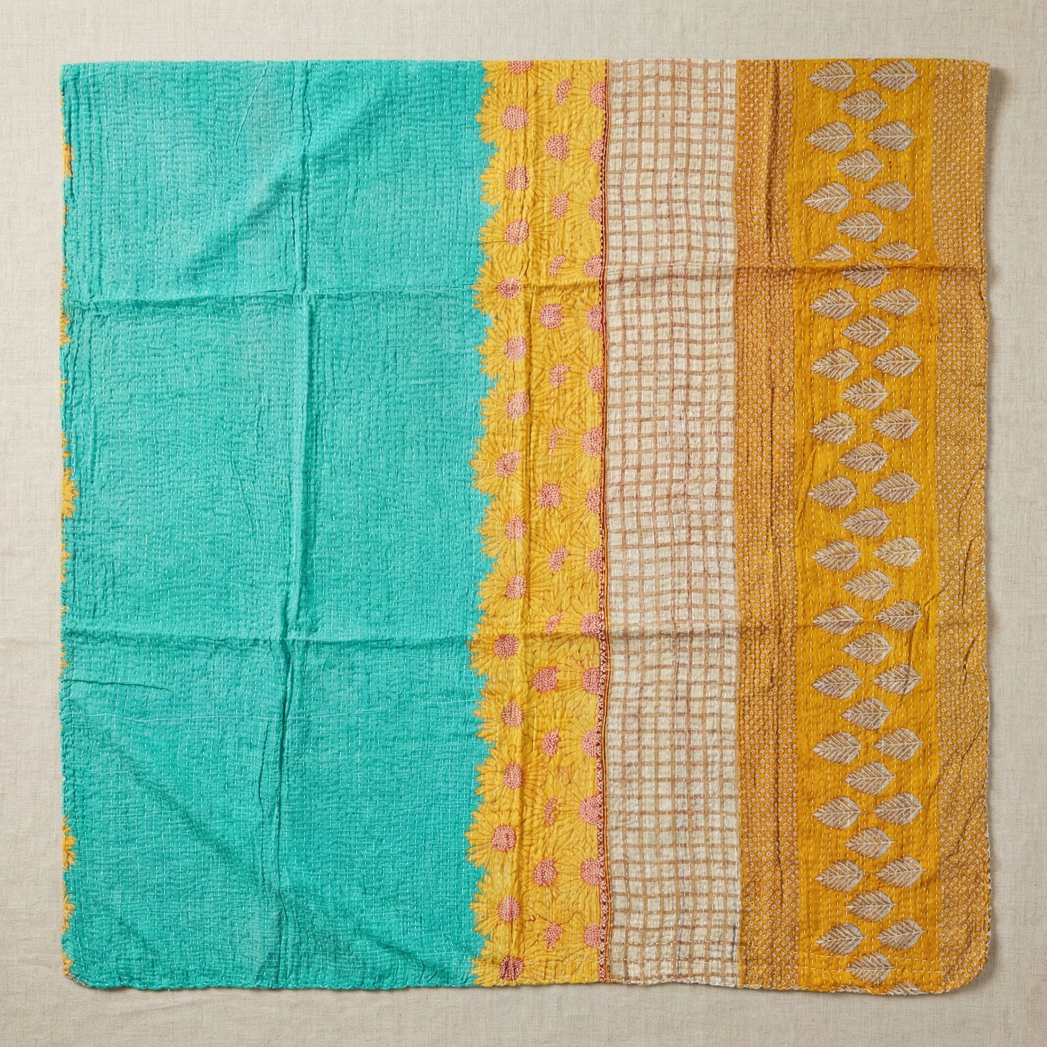 Textile with turquoise, yellow, and beige patterns on a beige background