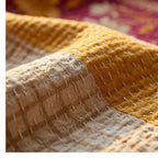 Close-up of a textured fabric with a checkered pattern in yellow and beige.