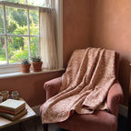 Trillium Bagru Kantha Throw — reverse side draped over a chair in a reading nook