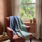 Cattail Bagru Kantha Throw — reverse side draped over a chair in a reading nook