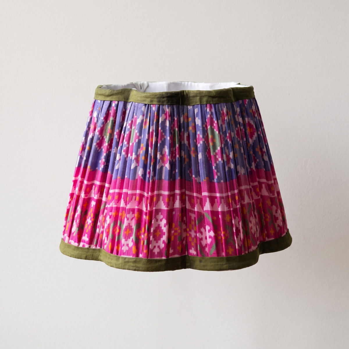 Close view of a handmade pleated lampshade and its fitting