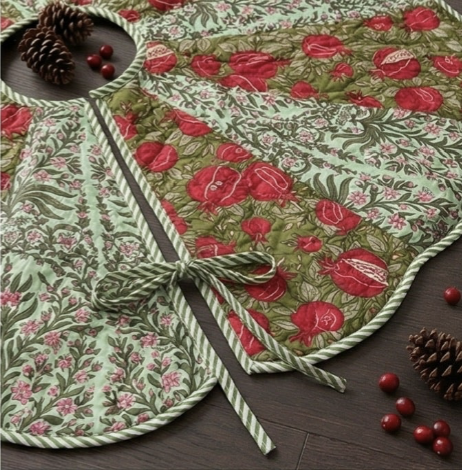 Green and red floral table runner with pinecones and berries on a wooden surface