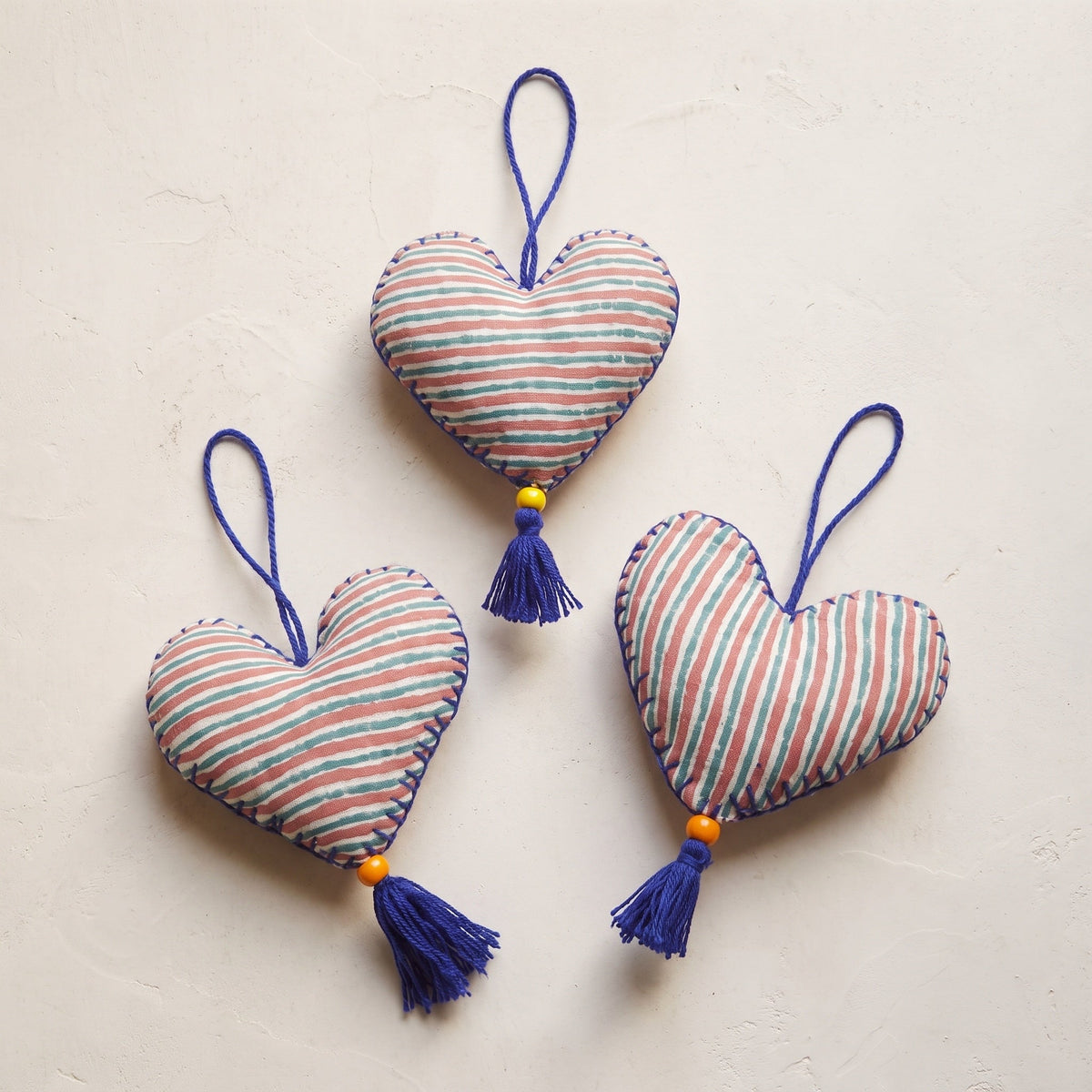 Non-beaded cotton heart Christmas ornament, Sky Fern design – studio view. Example from random assortment of six.