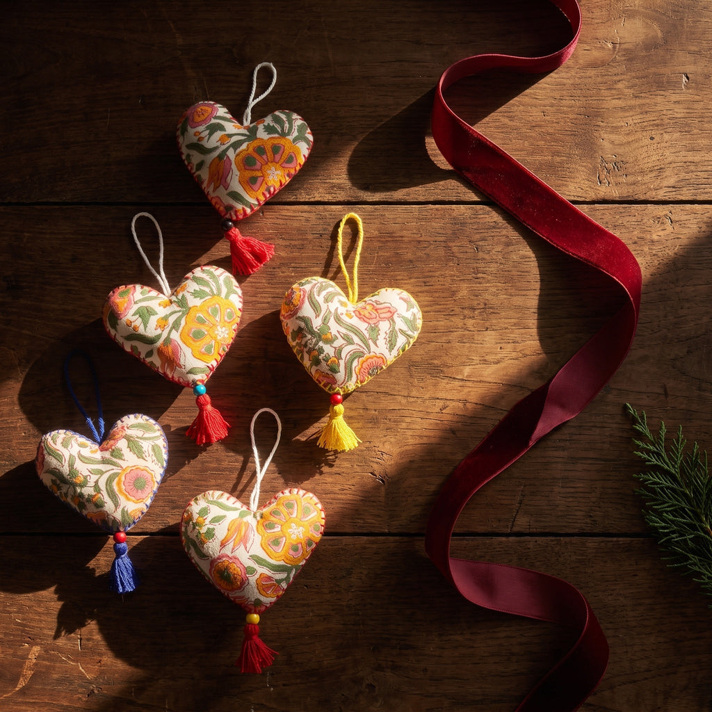 Non-beaded cotton heart Christmas ornament, Gentle Glow design – styled flat lay. Example from random assortment of six.