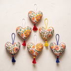Non-beaded cotton heart Christmas ornament, Gentle Glow design – studio view. Example from random assortment of six.