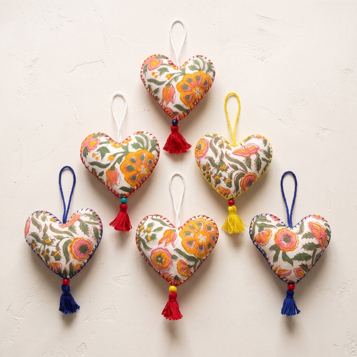 Non-beaded cotton heart Christmas ornament, Gentle Glow design – studio view. Example from random assortment of six.